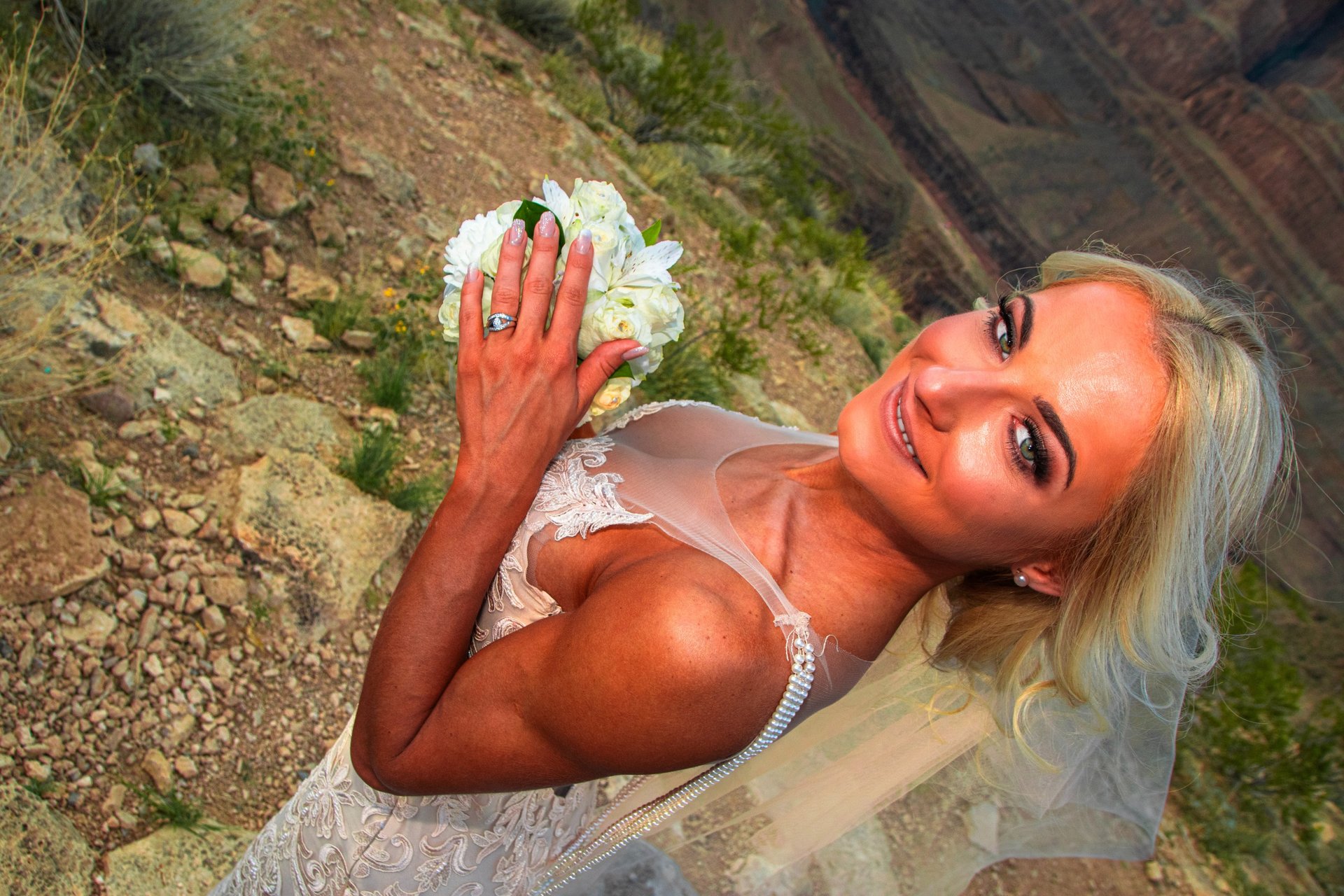 Bride showing wedding ring with flowers at Grand Canyon helicopter wedding ceremony